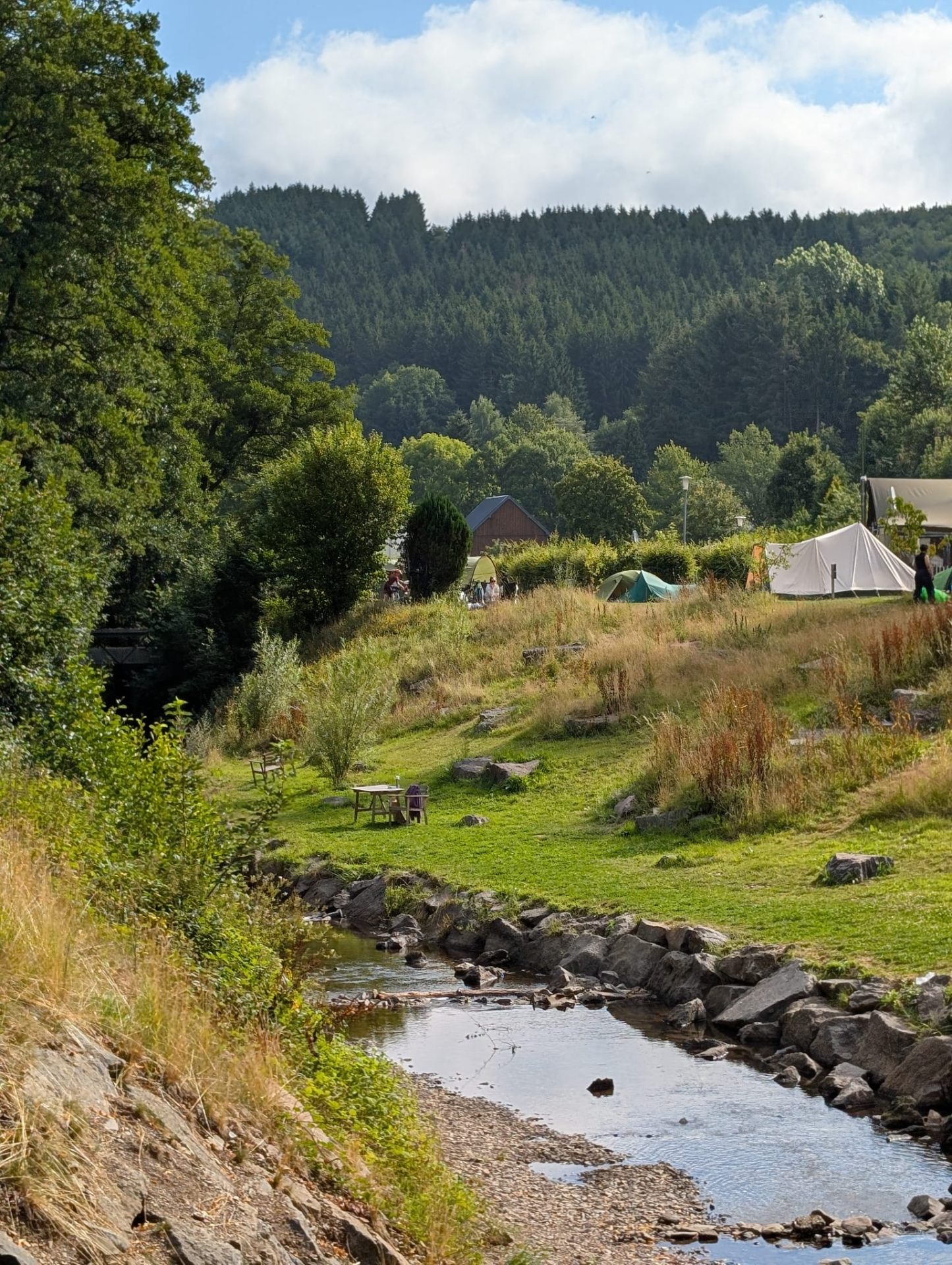 Blick auf Zelte am Bach