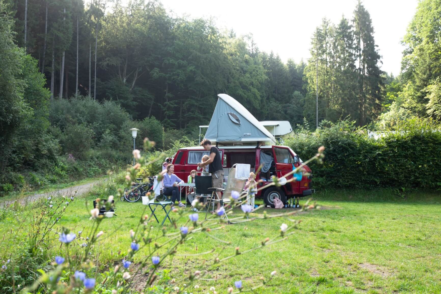 Familie beim Camping mit Kindern auf Wildbach Camping